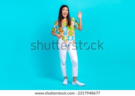 Full body cadre of positive friendly japanese hipster girl wear trendy clothes wave hand hello sign isolated on aquamarine color background