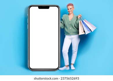 Full body cadre of young fashionista online buyer clothes shopping direct finger online menu calvin klein isolated on blue color background
