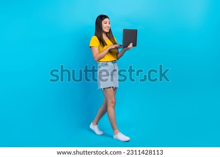 Full body cadre of young student girl order tickets sale lowcost promo use netbook app for booking online isolated on blue color background