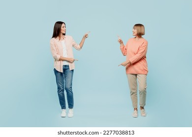 Full body cheerful cool confident elder parent mom with young adult daughter two women together wear casual clothes point fingers on each other isolated on plain blue background. Family day concept - Shutterstock ID 2277038813
