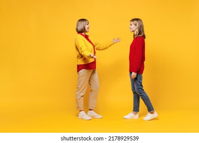 Full Body Cool Woman 50s In Red Shirt Have Fun With Teenager Girl 12-13 Years Old. Grandmother Granddaughter Meeting Together Spread Hands Isolated On Plain Yellow Background. Family Lifestyle Concept