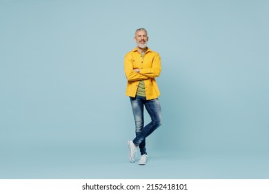 Full Body Elderly Gray-haired Mustache Bearded Man 50s Wear Yellow Shirt Hold Hands Crossed Folded Look Camera Isolated On Plain Pastel Light Blue Background Studio Portrait. People Lifestyle Concept