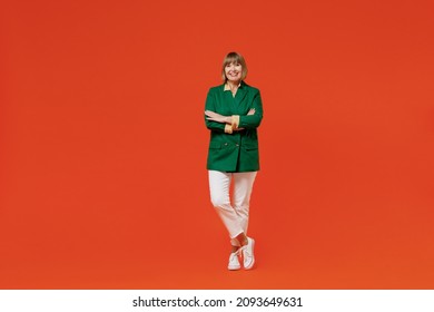 Full Body Elderly Smiling Happy Cool Confident Woman 50s In Green Classic Suit Hold Hands Crossed Folded Isolated On Plain Orange Color Background Studio Portrait. People Business Lifestyle Concept