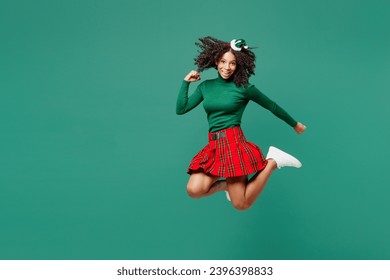 Full body excited merry little kid teen girl wear hat casual clothes posing do winner gesture isolated on plain green background studio portrait. Happy New Year celebration Christmas holiday concept - Shutterstock ID 2396398833