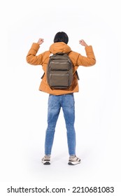 Full Body Fashion Model. Back View Young Man In Warm Jacket With Jeans With Backpack With Winner Gesture Posing In Studio