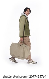 Full Body Fashion Model. Man In Warm Jacket With Khaki Pants Holding Handbag Walking In Studio On White Background