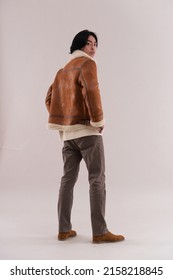 Full Body Fashion Model. Man In Warm Brow Jacket With Brown Jeans Posing In Studio