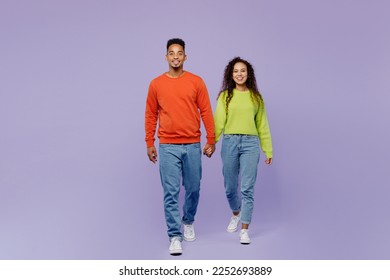 Full body front view young couple two friends family man woman of African American ethnicity wear casual clothes hold hands walk go strolling together isolated on pastel plain light purple background - Shutterstock ID 2252693889