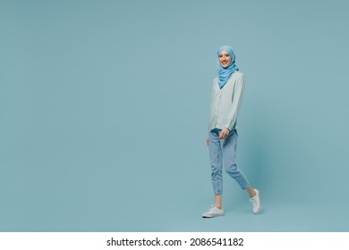 Full body fun young arabian asian muslim woman in abaya hijab hold hands crossed folded walk go isolated on plain blue background studio portrait. People uae middle eastern islam religious concept. - Shutterstock ID 2086541182
