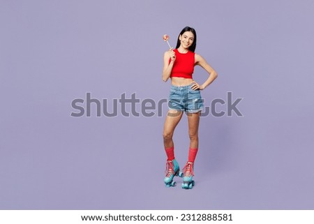 Full body fun young latin woman she wear red casual clothes rollers rollerblading hold in hand lollipop look camera isolated on plain pastel purple background. Summer sport lifestyle leisure concept