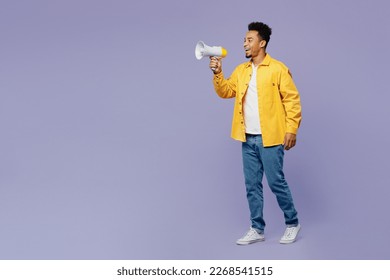 Full body fun young man of African American ethnicity wear yellow shirt t-shirt hold in hand megaphone scream announces discounts sale Hurry up isolated on plain pastel light purple background studio - Shutterstock ID 2268541515