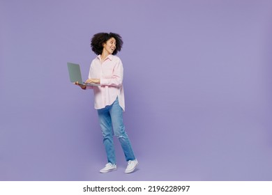 Full Body Fun Young Woman Of African American Ethnicity 20s Wear Pink Striped Shirt Hold Use Work On Laptop Pc Computer Look Aside On Workspace Isolated On Plain Pastel Light Purple Background Studio