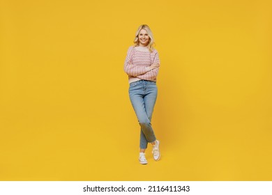 Full Body Happy Elderly Smiling Blonde Caucasian Woman 50s In Pink Sweater Looking Camera Hold Hands Crossed Folded Isolated On Plain Yellow Color Background Studio Portrait. People Lifestyle Concept