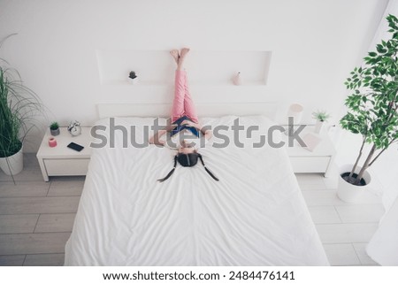 Full body high angle view portrait of adorable small girl sleep hold book wear pajama comfy bed bedroom apartment indoors