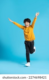 full body image of asian boy posing on blue background - Shutterstock ID 2274698421
