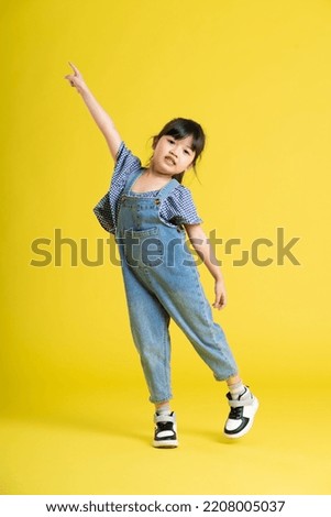 full body image of beautiful asian baby girl on yellow background