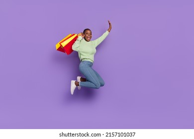 Full body image of good mood laughing woman excited after shopping buy many clothes isolated on violet color background