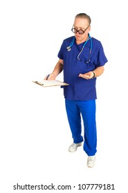 Full Body Image Of Male Nurse Or Doctor With Chart And Stethoscope Around Neck,  Holding A Handful Of Pills, Isolated On White