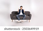 Full body image of young Asian man posing on sofa on white background