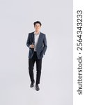 Full body image of a young Asian business man posing on a white background