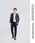 Full body image of a young Asian business man posing on a white background