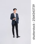 Full body image of a young Asian business man drink coffe and posing on a white background