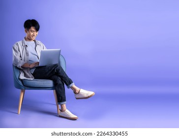 full body image of young asian man using laptop on purple background
 - Powered by Shutterstock