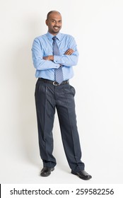 Full Body Indian Businessman Arms Crossed Standing On Plain Background With Shadow 