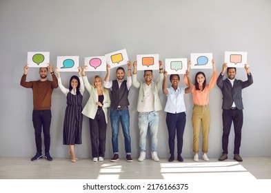 Full body length group happy diverse multiracial multiethnic people showing various paper sheets, cards and banners with pictures of different speech clouds and message bubbles. Communication concept