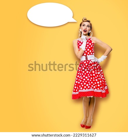Full body length image of thinking woman in red pin up dress. Blond pinup thougthfull girl in studio, on yellow background. White empty blank speech sign bubble, having idea.