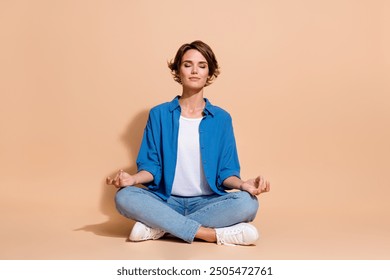 Full body length photo of carefree young woman in blue shirt business owner balance practicing isolated on beige color background