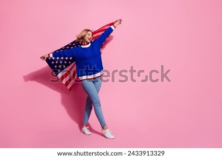 Full body length photo of lady wear stylish blue jumper and jeans holding patriot american festive flag isolated on pink color background