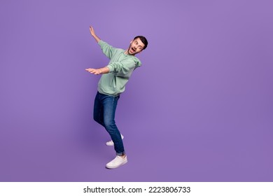 Full body length photo of young nervous funny man excited falling down no balance dangerous look empty space shocked isolated on violet color background