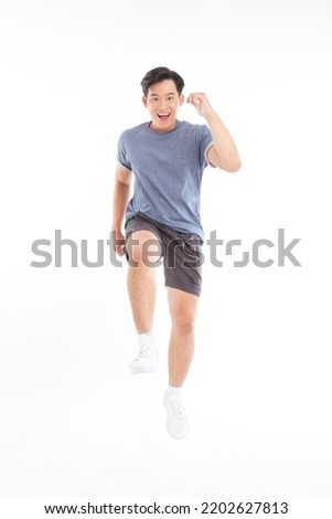Full body length photo of a young handsome Asian adult man, in sport workout exercise casual wear. Concept of healthy and active lifestyle.