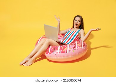 Full Body Length Sad Tired Young Woman Wear Red Blue Swimsuit Sit On Inflatable Ring Work On Pc Laptop Isolated On Vivid Yellow Color Wall Background Studio. Summer Hotel Pool Sea Rest Sun Tan Concept