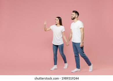 Full Body Length Side Profile View Young Lovely Couple Two Friends Man Woman In White Basic Blank Print Design T-shirt Jeans Walk Go Move Step Isolated On Pastel Pink Color Background Studio Portrait