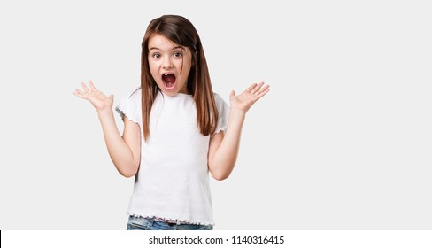 Full body little girl screaming happy, surprised by an offer or a promotion, gaping, jumping and proud