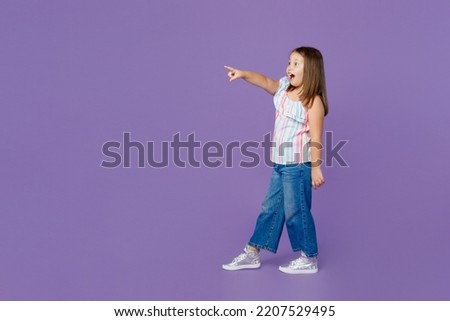 Full body little kid child girl 6-7 years old wear casual clothes point index finger aside on workspace area isolated on plain pastel light purple background Mother's Day love family lifestyle concept