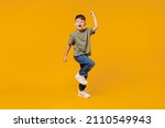 Full body little small fun happy boy 6-7 years old wearing green t-shirt do winner gesture clench fist isolated on plain yellow background studio portrait. Mother