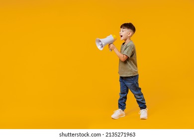 Full Body Little Small Smiling Happy Boy 6-7 Years Old In Green T-shirt Hold Scream In Megaphone Announces Discounts Sale Hurry Up Isolated On Plain Yellow Background. Mother's Day Love Family Concept