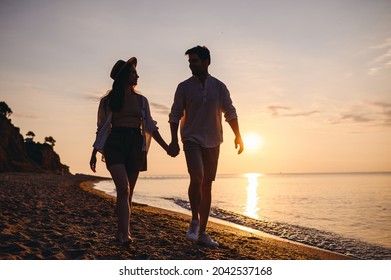 Full Body Lower Silhouette Young Couple Two Friends Family Man Woman In Casual Clothes Hold Hand Look To Each Other Walk Together At Sunrise Over Sea Beach Ocean Outdoor Seaside In Summer Day Evening