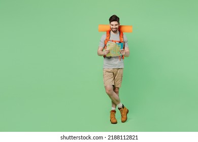 Full body mountaineer young traveler white man carry backpack stuff mat walk read map isolated on plain green background. Tourist leads active healthy lifestyle. Hiking trek rest travel trip concept - Powered by Shutterstock