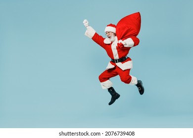 Full body old Santa Claus man 50s in Christmas hat red suit clothes jump like super hero with gifts bag isolated on plain blue background studio. Happy New Year 2022 merry ho x-mas holiday concept. - Powered by Shutterstock