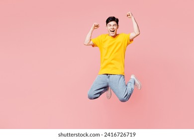 Full body overjoyed excited cool fun young man he wearing yellow t-shirt casual clothes jump high do winner gesture isolated on plain pastel light pink background studio portrait. Lifestyle concept - Powered by Shutterstock