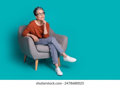 Full body photo of attractive senior woman sit armchair look minded empty space dressed brown clothes isolated on cyan color background - Powered by Shutterstock