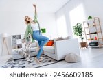 Full body photo of attractive young woman raise hand good mood dancing wear trendy green clothes living area bright interior design