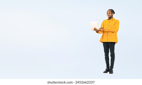 Full body photo of a black man looking at laptop