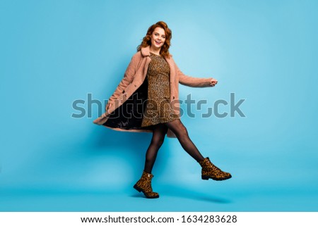Full body photo of candid content woman enjoy free time rest relax weekend fooling raise hands wear tights vogue footwear isolated over blue color background