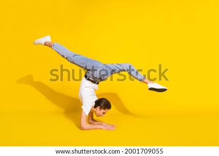 Similar – Man practicing yoga, handstand against a yellow wall