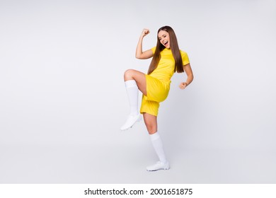 Full Body Photo Of Cheerful Crazy Sports Fan Lady Raise Fists Leg Support Players Wear Favorite Football Team Yellow Uniform T-shirt Shorts Long Socks Cleats Isolated White Color Background